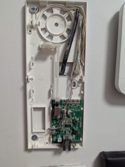 Disassembled intercom housing showing PCB and connected wires