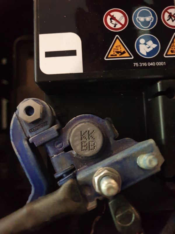 Zbliżenie na baterię z oznaczeniem KKBB na zacisku.