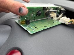 Close-up of a circuit board with yellow-marked pins and cables.