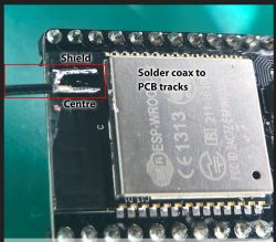 Close-up of an ESP chip with an antenna soldered to the PCB tracks.