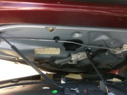 Wnętrze klapy bagażnika auta z siłownikiem, wiązką przewodów i mechanizmem zamka