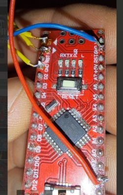 Close-up of an Arduino Nano module with attached wires.