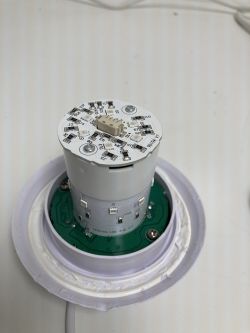 Close-up of an LED lamp interior with electronic components on a white background.