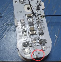 Close-up of a circuit board with various electronic components and soldered wires, with an element marked in red.