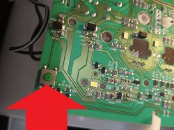 Zbliżenie na płytkę elektroniczną z zielonym przyciskiem
