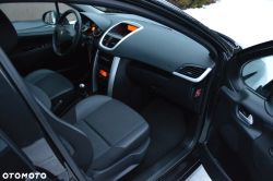 Car interior through an open front door: front seats, dashboard, and steering wheel