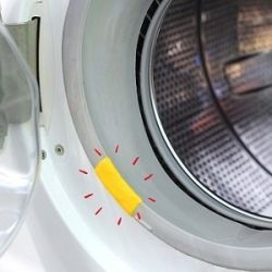 Naprawiony fartuch pralki z żółtym materiałem uszczelniającym przy otworze bębna