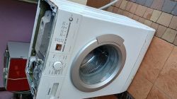 Zdjęcie pralki Siemens X10-36 z otwartą górną pokrywą, ustawionej na tarasie.