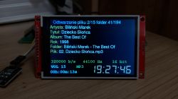Color display showing an audio player with Polish characters and track metadata
