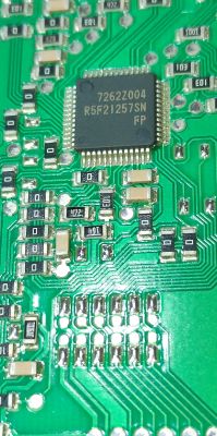 R5F21257SN chip on green printed circuit board Close-up of green PCB with R5F21257SN integrated circuit and surface components