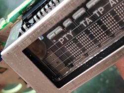 Zbliżenie wnętrza radia samochodowego z widocznym wyświetlaczem i elementami elektronicznymi.