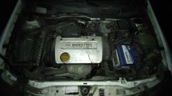 Silnik samochodowy marki Opel z pokrywą ECOTEC i akumulatorem Varta.