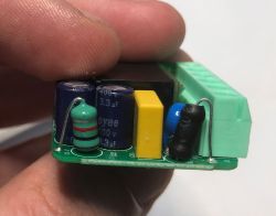 Close-up of electronics inside Sonoff relay, visible capacitors and resistor