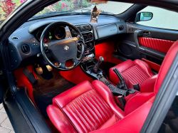 Interior of an Alfa Romeo car with red leather seats.
