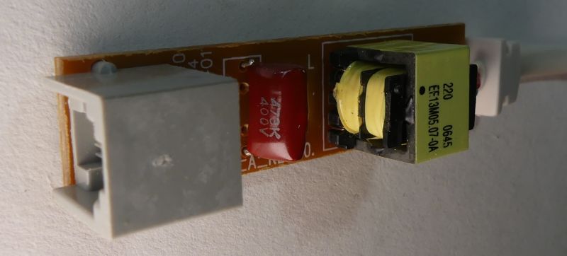 Moduł elektroniczny z transformatorem i kondensatorem na płytce drukowanej.