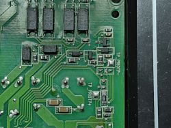 Close-up of PCB with surface-mounted components Section of green PCB with SMD electronic components and labels TP_PRIOTP+ and TP_PRIOTP-