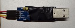Wires soldered to a USB-UART PL2303 module wrapped in electrical tape.