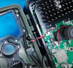 Interior of an electronic device with a visible motherboard and wiring.