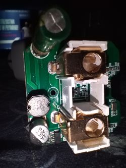 Close-up of a circuit board with electronic components and large brass connectors.