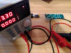 Workbench with a power supply and electronic board connected to a USB UART CH340G adapter.
