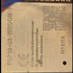 Close-up of an ESP32-WROOM module with engraved text and a QR code.