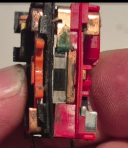 Worn electrical contact with corrosion signs Close-up of a worn and corroded electrical contact in a plastic housing
