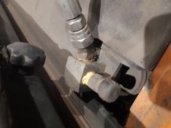 Zbliżenie na element instalacji gazowej z podłączonym wężem i złączkami metalowymi