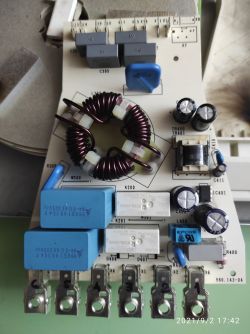 Image of a circuit board with various electronic components, including a coil and capacitors.