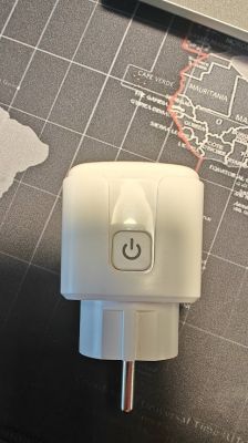 Front View of a White Smart Plug White smart plug with a power button on a dark background.