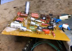 Close-up of a PCB with through-hole components and wires on a workshop bench