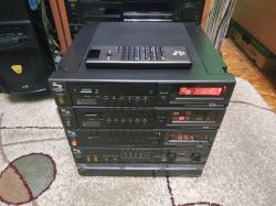 Stack of Schneider DCS audio devices from the 1980s on a carpet, with a remote on the top unit.
