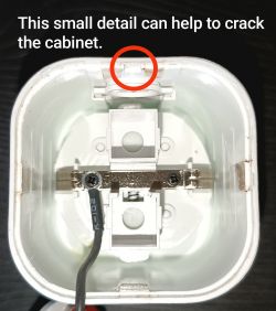 View of the interior of a device with a detail circled in red and text indicating that this detail can help open the cabinet.