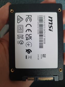 Dysk SSD MSI SPATIUM S270 SATA 2.5 cala trzymany w dłoni, widoczne cztery otwory montażowe na rogach.