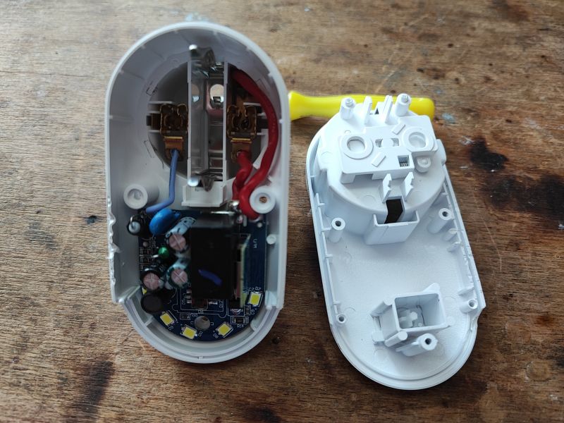 Rozebrana obudowa inteligentnej wtyczki z podświetleniem LED, widoczny przekaźnik i diody LED.