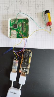 Prototype board with a microcontroller and wires, lying on a sheet with handwritten notes. Nearby are serial communication devices.