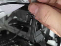 Zbliżenie na rękę trzymającą przewody Power SW i inne do podłączenia na płycie głównej