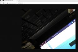Photo showing a laptop keyboard and screen, partially visible in a browser at IP address 192.168.0.155.
