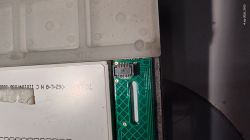 Close-up of flexible ribbon cable connector on a green printed circuit board