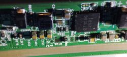 Zbliżenie na płytkę drukowaną z widocznymi elementami elektronicznymi, w tym układ 211000 i diody SSL34B.