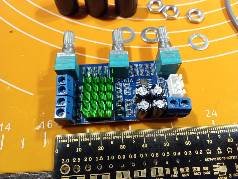 Moduł elektroniczny z potencjometrami na żółtym tle z miarką.