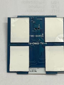 Top view of an electronic module with four large white areas on a blue printed circuit board.
