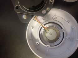 Disassembled smoke sensor with visible red, yellow, and black wires.