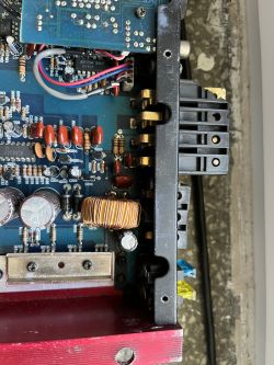 Widok wnętrza wzmacniacza samochodowego z widocznymi elementami elektronicznymi.