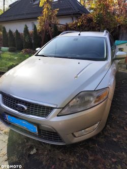 Silver Ford Mondeo estate car parked in front of a house in an autumn garden.