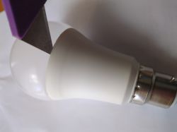 LED bulb cut with a knife with a purple handle.