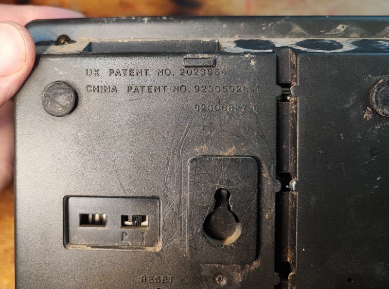 Dół obudowy telefonu stacjonarnego Proton T1332 z widocznymi patentami.