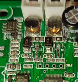 Zbliżenie na płytkę PCB z elementami w obudowach SOT89-5, cewkami i kondensatorami.