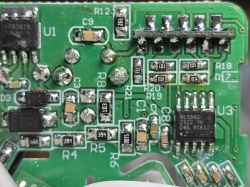 Close-up of a green PCB with ICs, SMD resistors and capacitors, and visible solder joints.