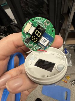 Open WiFi thermostat for an electric towel radiator, showing the circuit board and display.