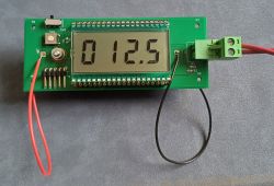 Płytka PCB z wyświetlaczem LCD pokazującym 012.5, przyciskiem i zielonym złączem zaciskowym